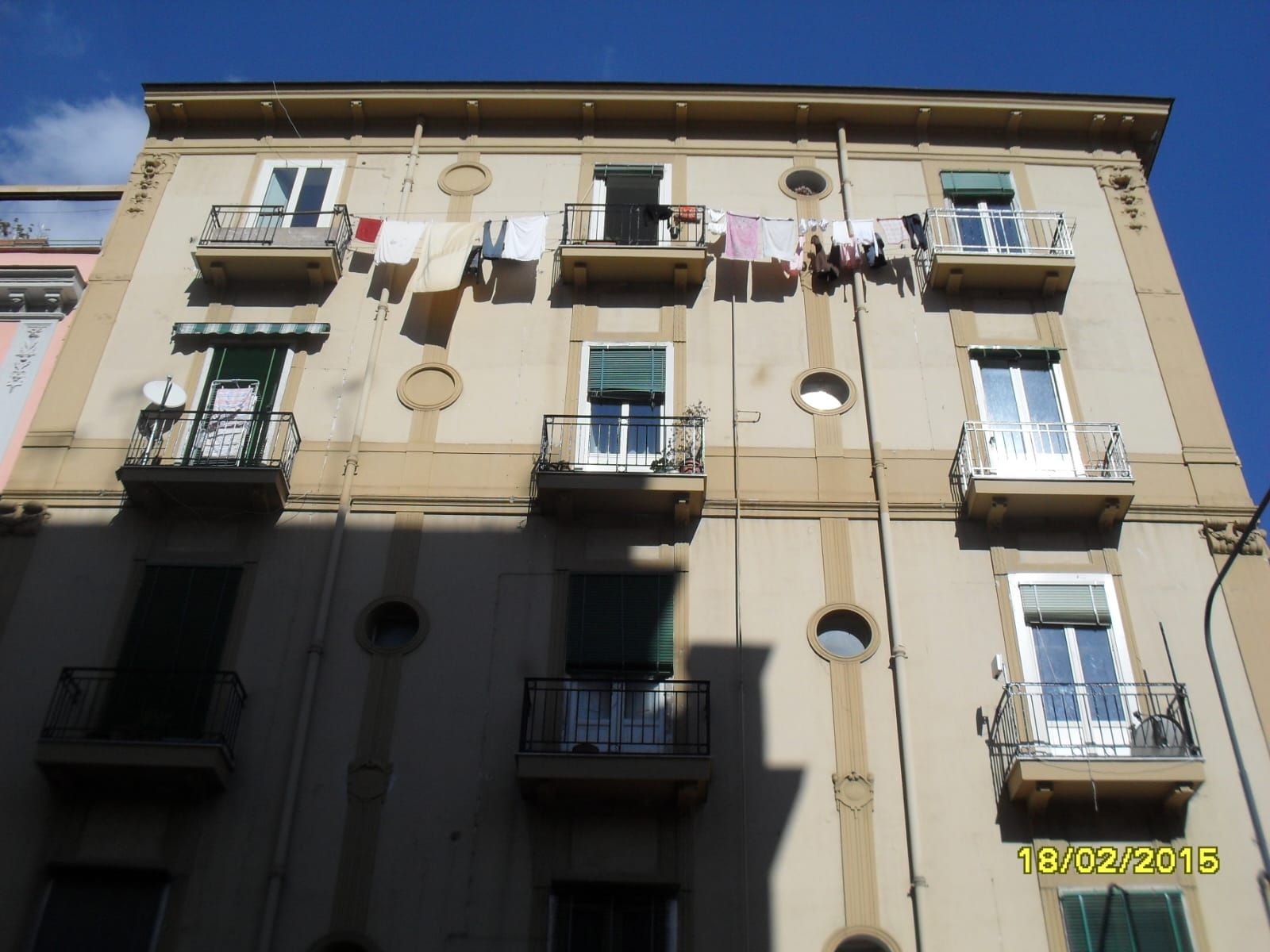 Un edificio con molti balconi e vestiti appesi su di essi