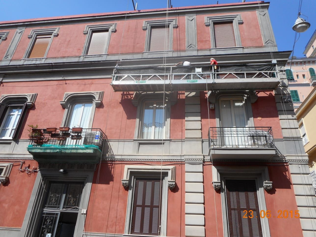 Un uomo è in piedi su un'impalcatura sul lato di un edificio