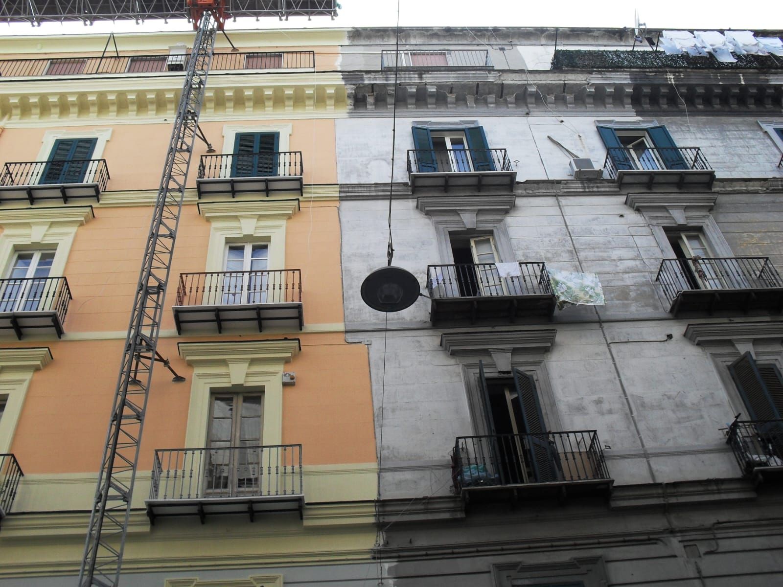 Un edificio con balconi e una gru di fronte