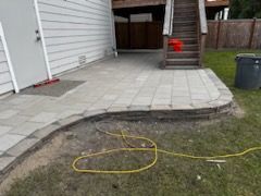 A patio is being built in the backyard of a house.