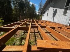 A wooden deck is being built in front of a house.