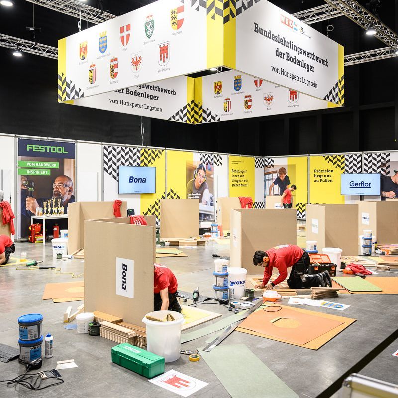Zwei Männer spielen auf einer Messe Tischfußball. Einer ist konzentriert, der andere schaut nach unten.