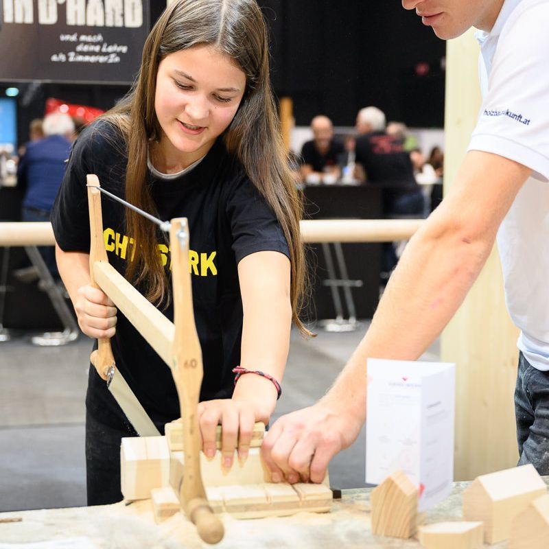 Junge mit Handschuhen bedient Maschinen bei einer Veranstaltung.