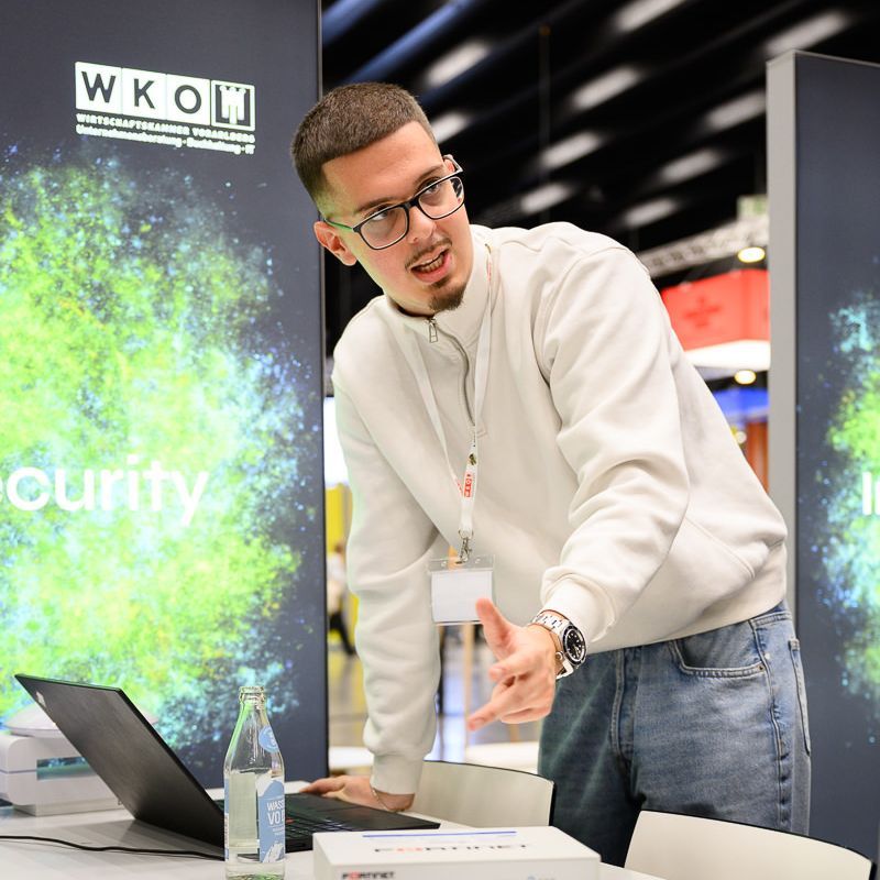 Mädchen lernt bei einer Haarshow unter Anleitung eines Lehrers an einer Schaufensterpuppe das Frisieren der Haare.