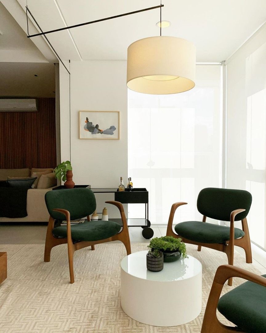 Uma sala de estar com cadeiras verdes e mesa branca