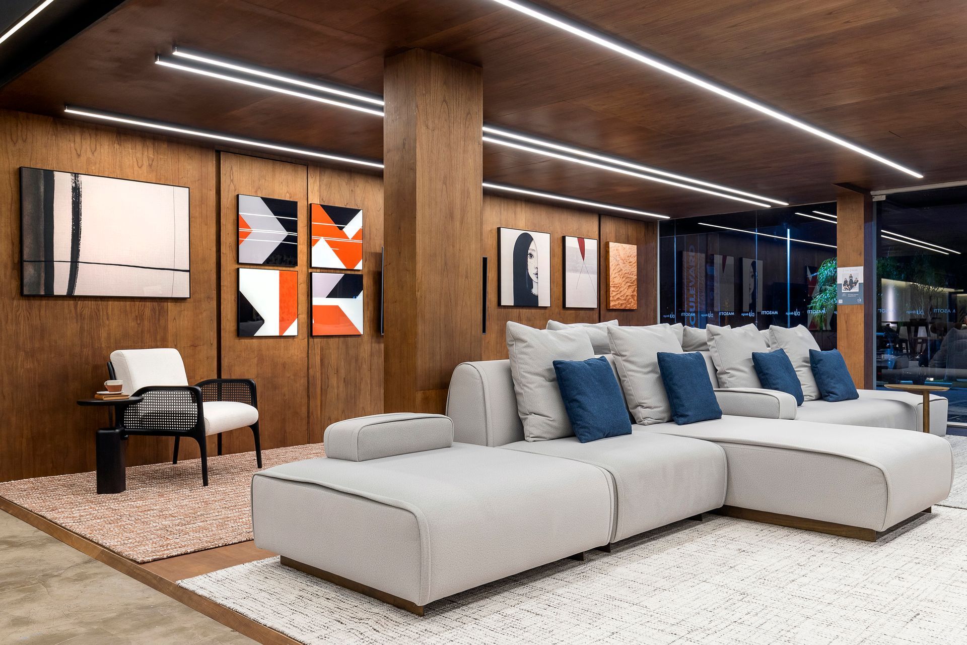 Uma sala com sofá, cadeira e quadros na parede.