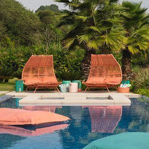 Duas cadeiras estão ao lado de uma piscina.