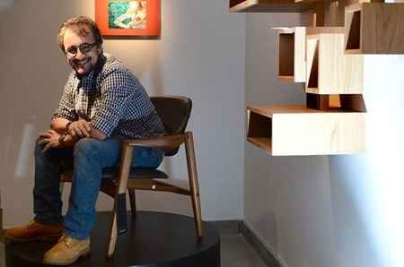 Um homem está sentado numa cadeira numa sala.