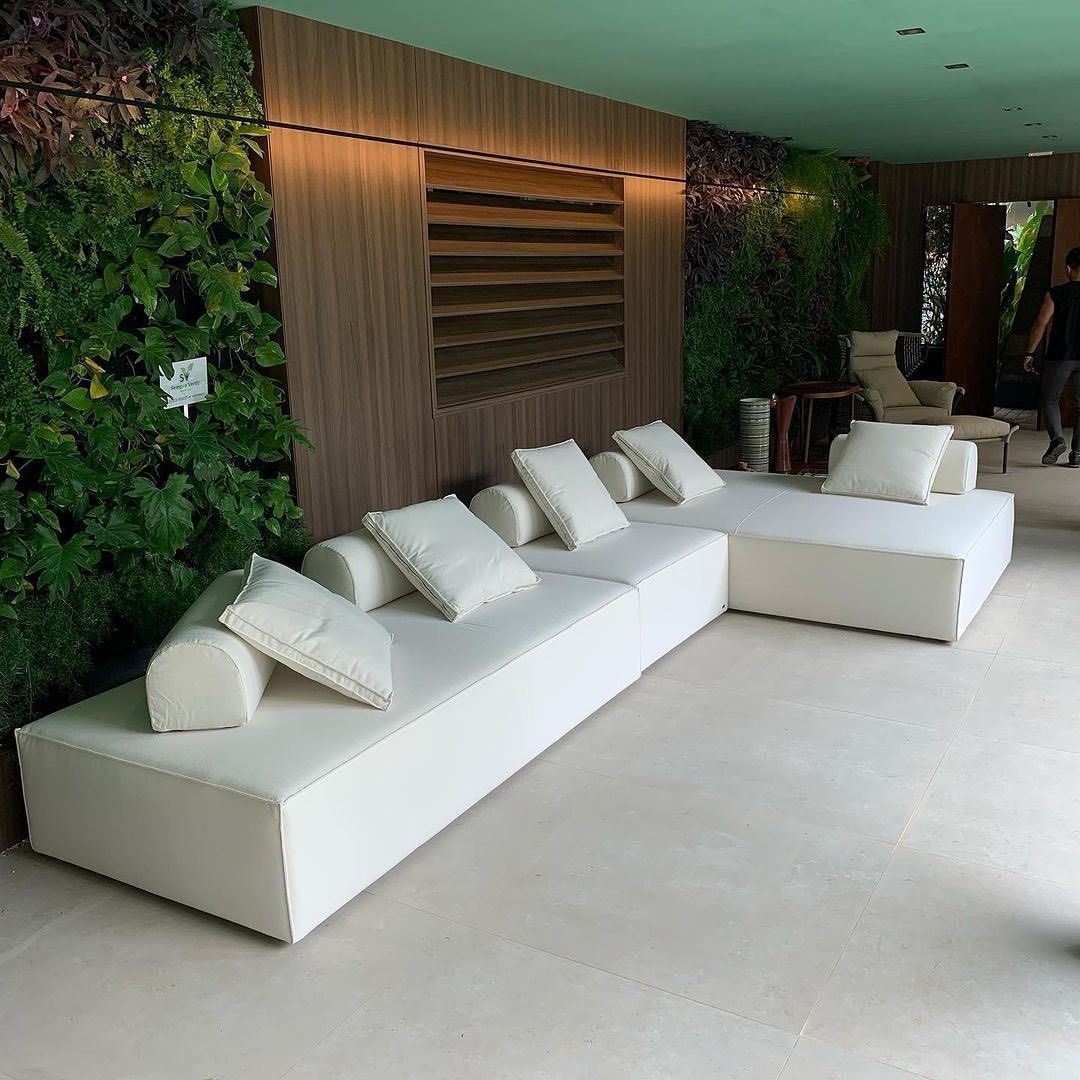 Uma sala com sofá e cadeiras e uma parede verde.