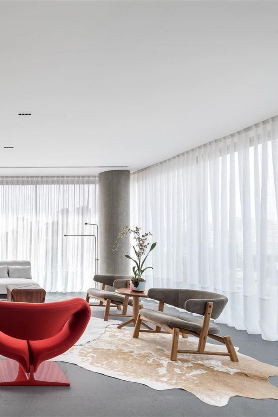 Uma sala de estar com cadeira vermelha e tapete