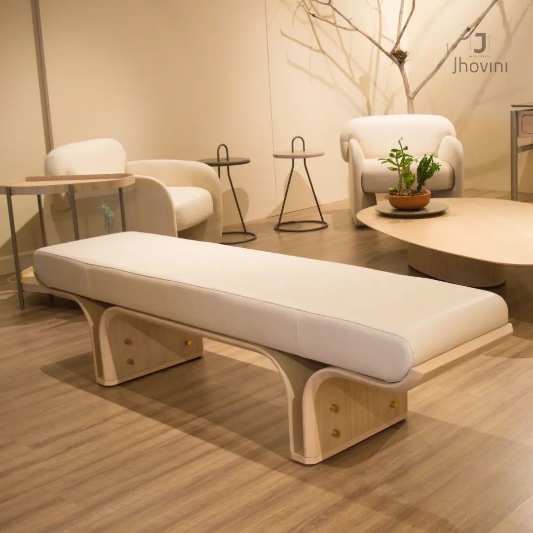 Um banco branco está em uma sala de estar com cadeiras e mesas