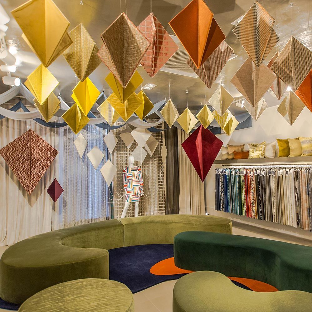 Uma sala com um sofá e um manequim pendurado no teto