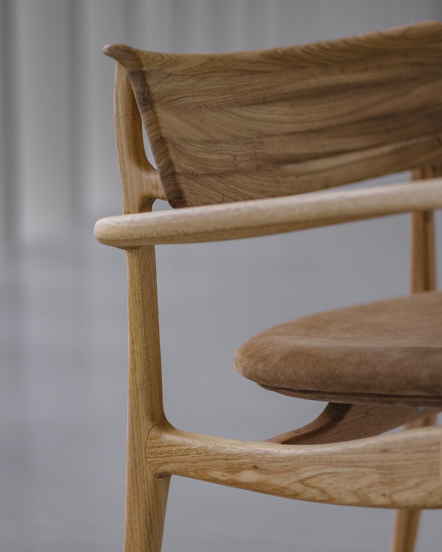 Um close de uma cadeira de madeira com uma almofada marrom.