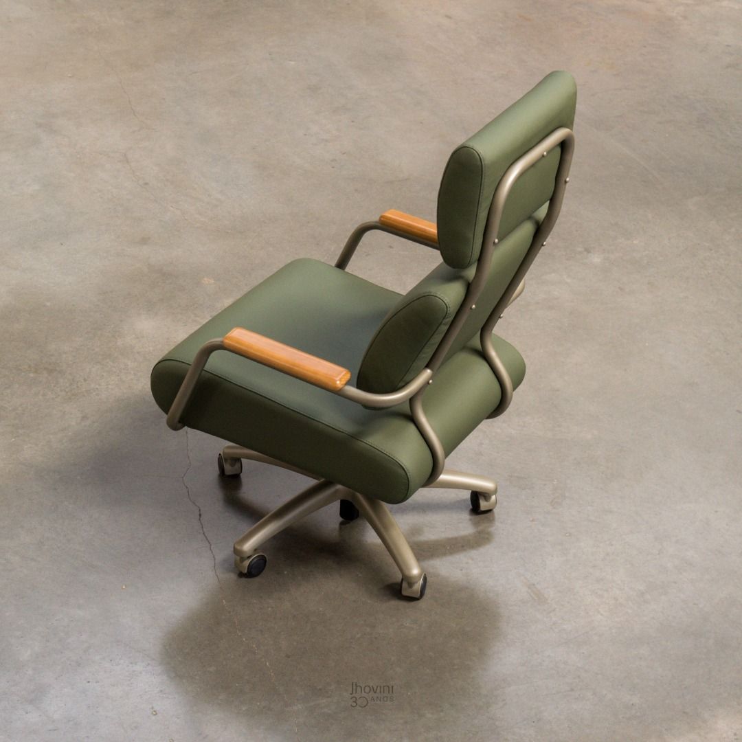 Uma cadeira de escritório verde está sentada em um chão de concreto