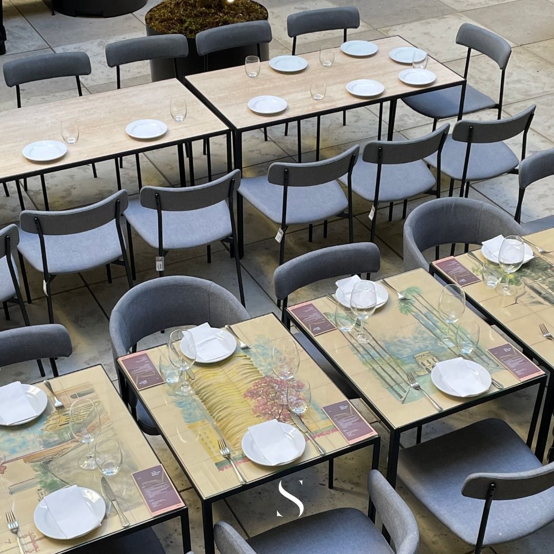 Uma fileira de mesas e cadeiras com pratos e copos