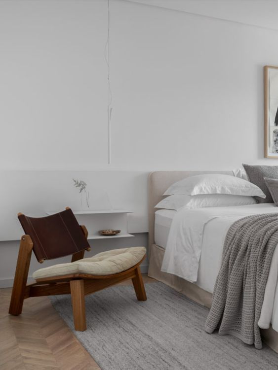 Um quarto com cama, cadeira e tapete.