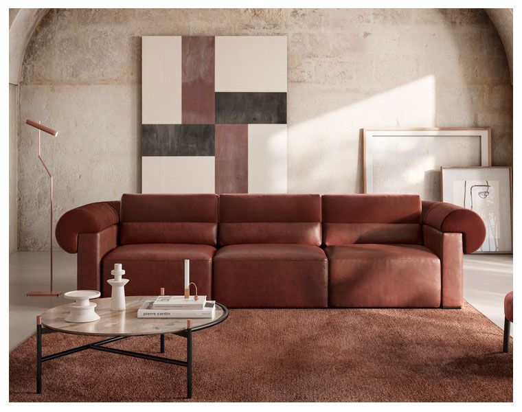 Uma sala de estar com sofá, mesa de centro e pinturas na parede.