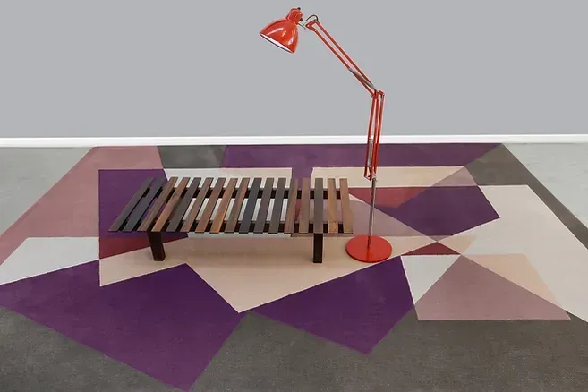 Um tapete roxo com um banco e uma luminária