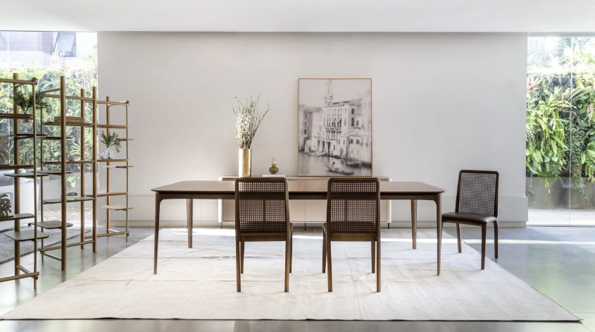 Sala de jantar com mesa e cadeiras e uma pintura na parede