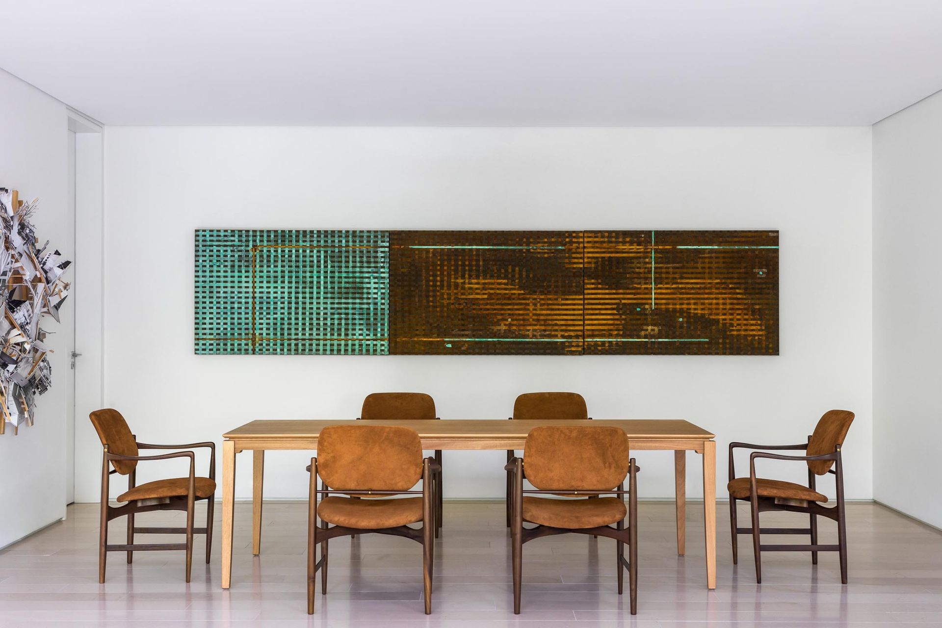 Uma sala de jantar com mesa e cadeiras e pinturas na parede