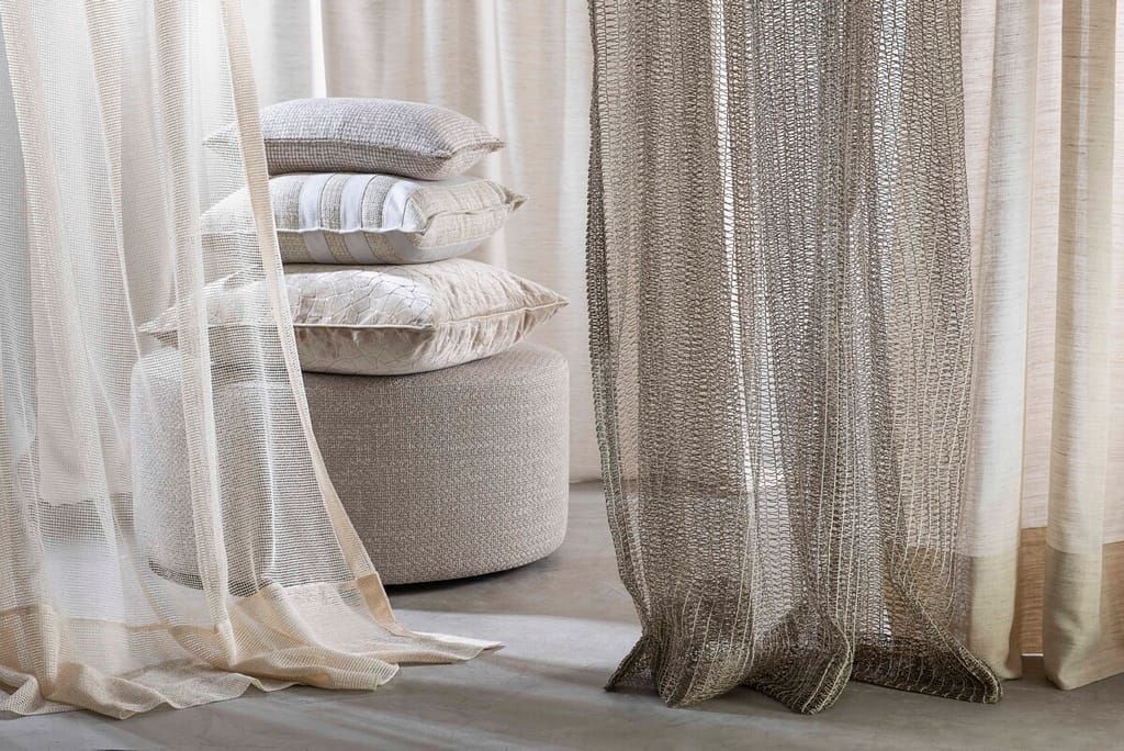 Um quarto com uma pilha de travesseiros e cortinas.