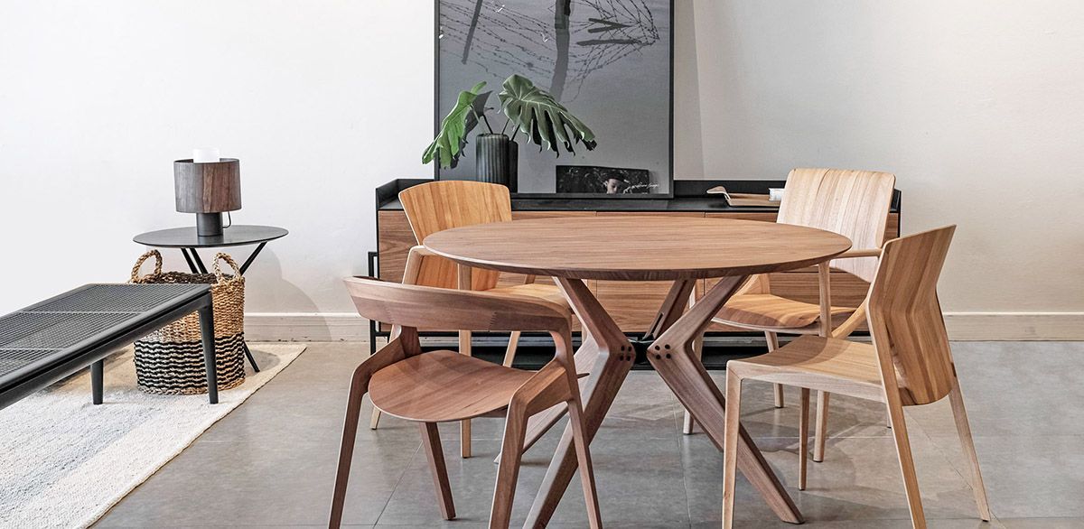 Sala de jantar com mesa redonda e cadeiras de madeira.