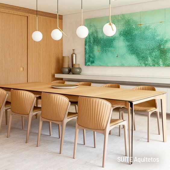 Sala de jantar com mesa e cadeiras e uma pintura na parede