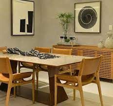 Uma sala de jantar com mesa e cadeiras e pinturas na parede.