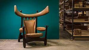 Uma cadeira com chifres está em uma sala ao lado de uma prateleira.