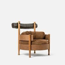 Uma cadeira de couro marrom com moldura de madeira sobre fundo branco.