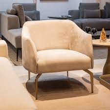 Uma cadeira branca está em uma sala de estar ao lado de um sofá.