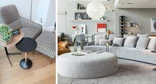 Uma sala de estar com sofá, cadeira, mesa e pufe.