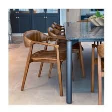 Mesa de jantar com tampo de vidro e cadeiras de madeira.