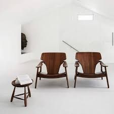 Duas cadeiras de madeira e um banco de madeira estão lado a lado em uma sala.