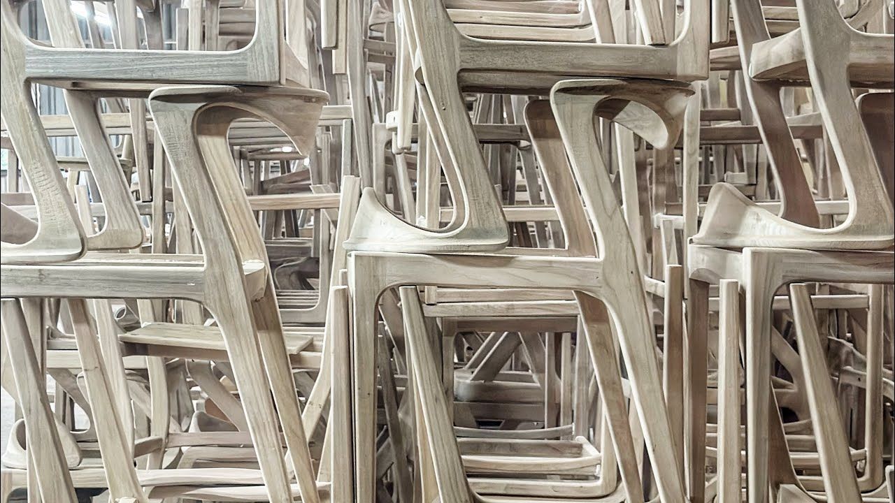 Um monte de cadeiras de madeira estão empilhadas umas sobre as outras.