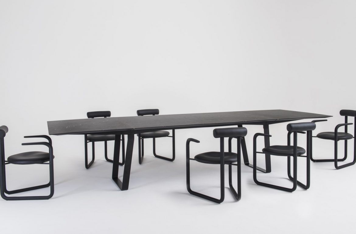 Uma longa mesa com cadeiras ao redor sobre um fundo branco