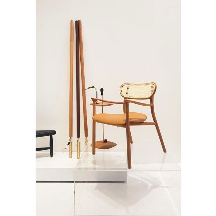 Uma cadeira de madeira com encosto de vime está em exposição