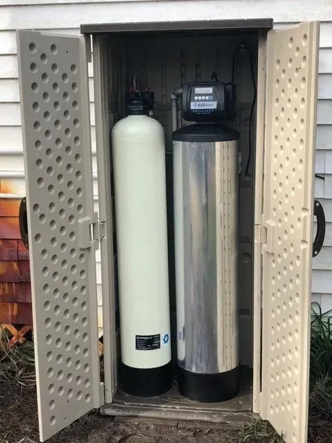 Two water filters are sitting inside of a plastic shed.