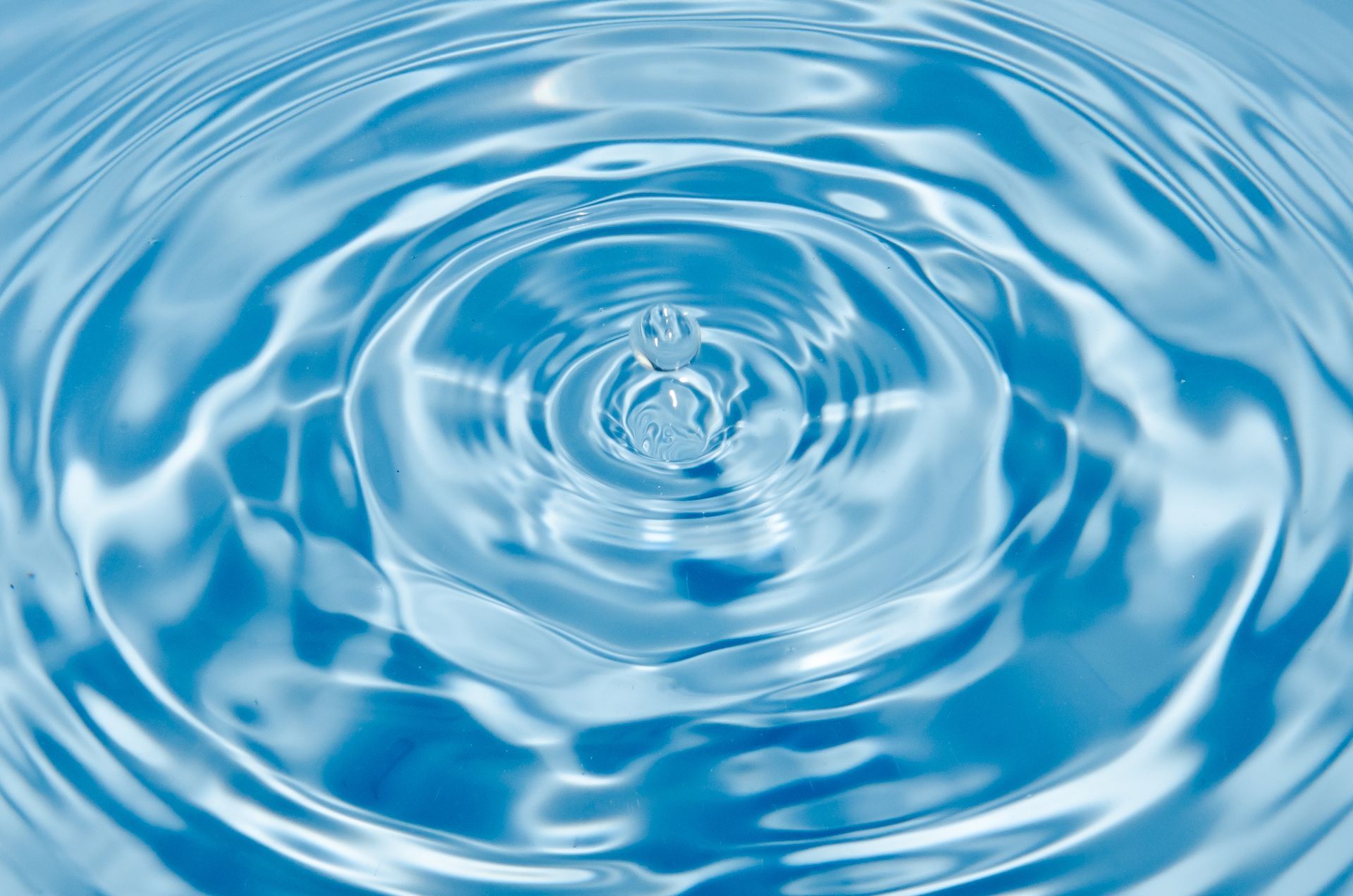 A close up of a circle of water on a blue background