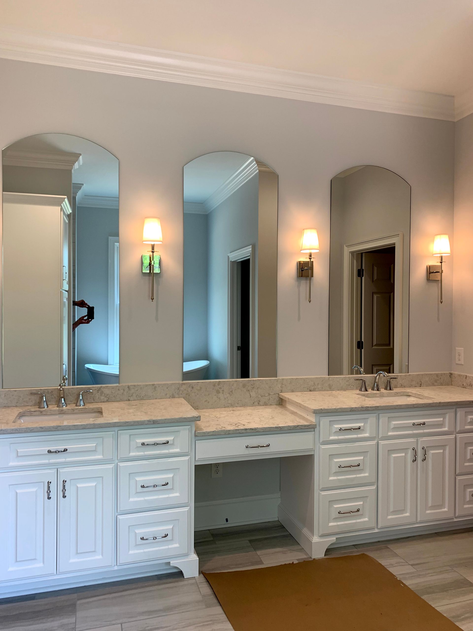 A bathroom with two sinks and three mirrors.