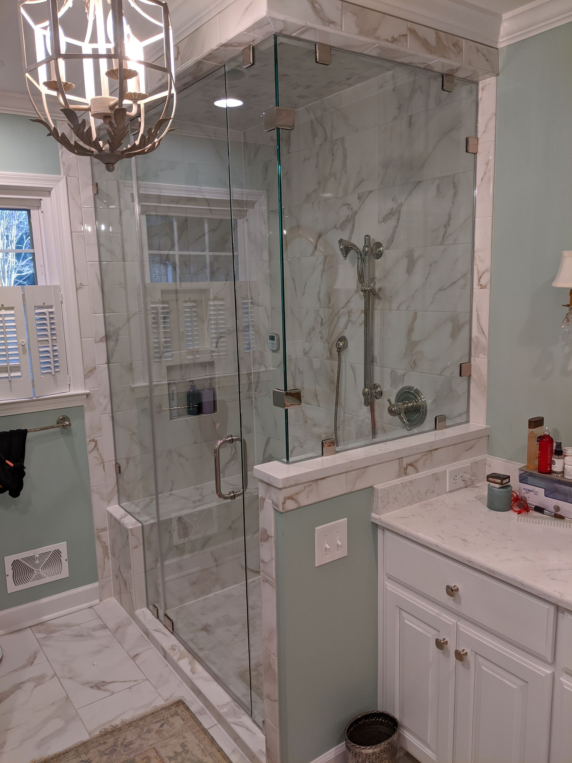 A bathroom with a walk in shower and a sink.