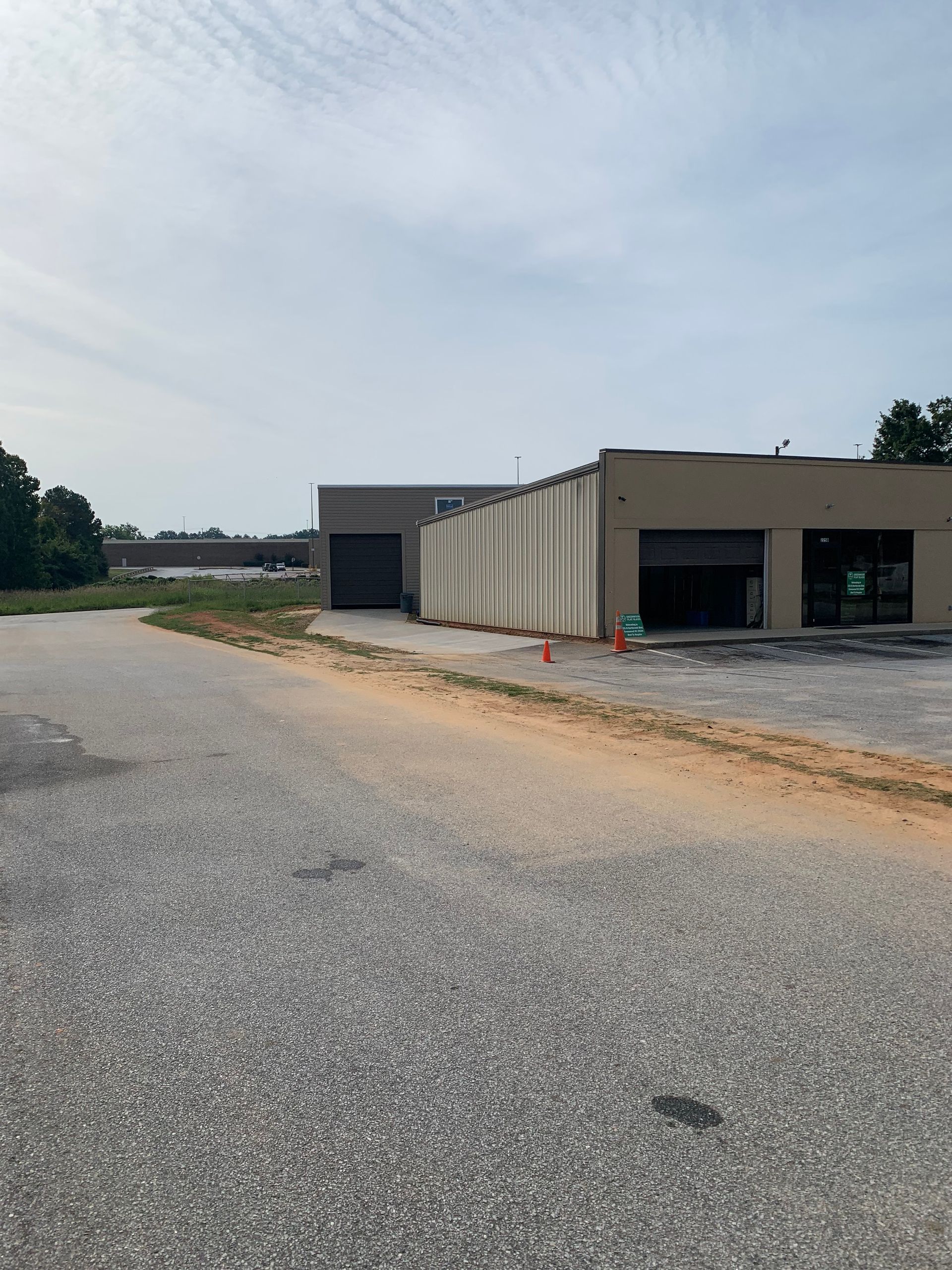 Two men are standing in an empty room with black walls