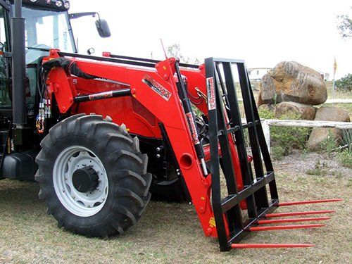 A photo of a McCormack Five Spear Hay Frame Front End Loader Attachment fitted to a tractor