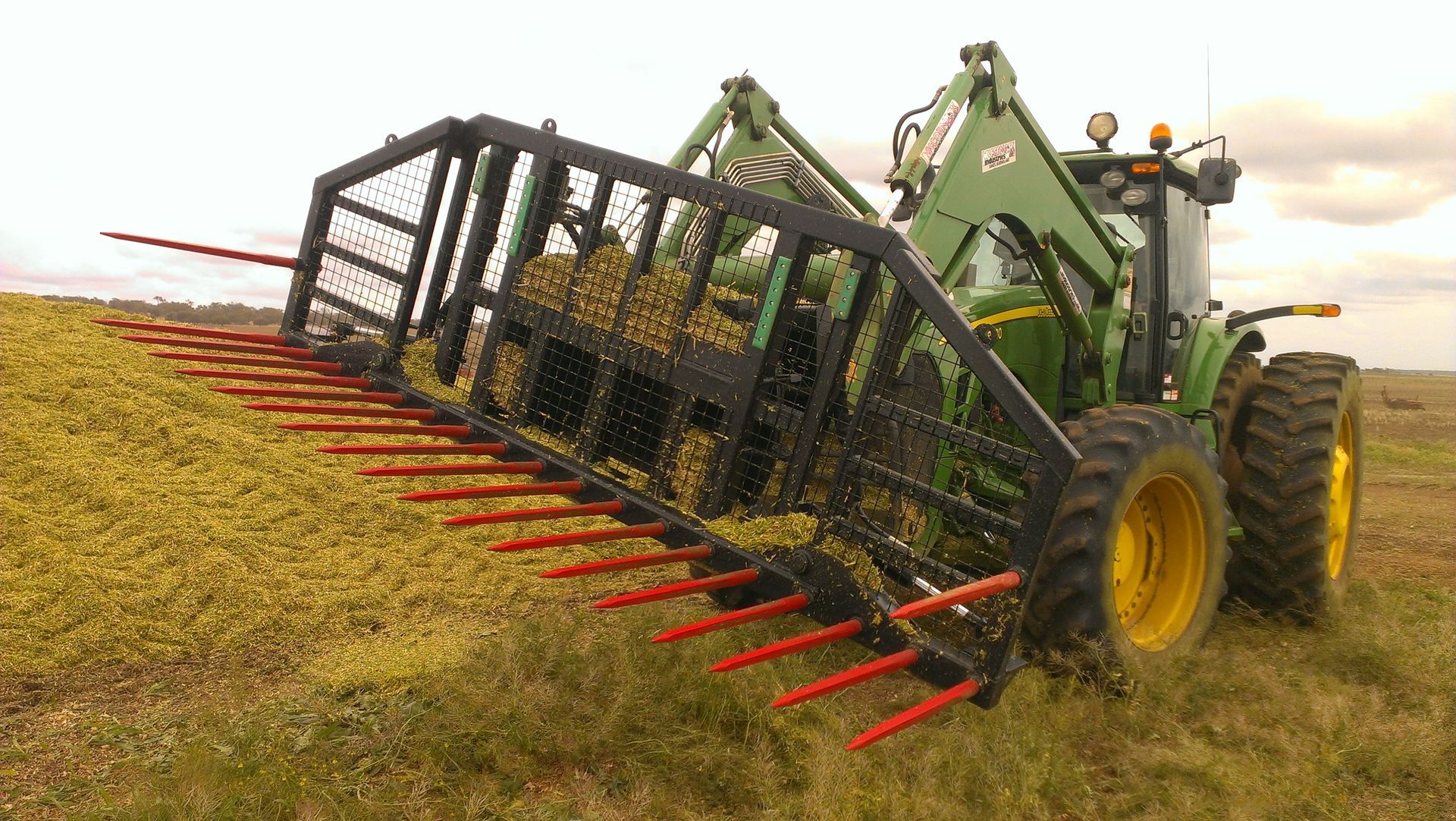 John Deere tractor with silage rake