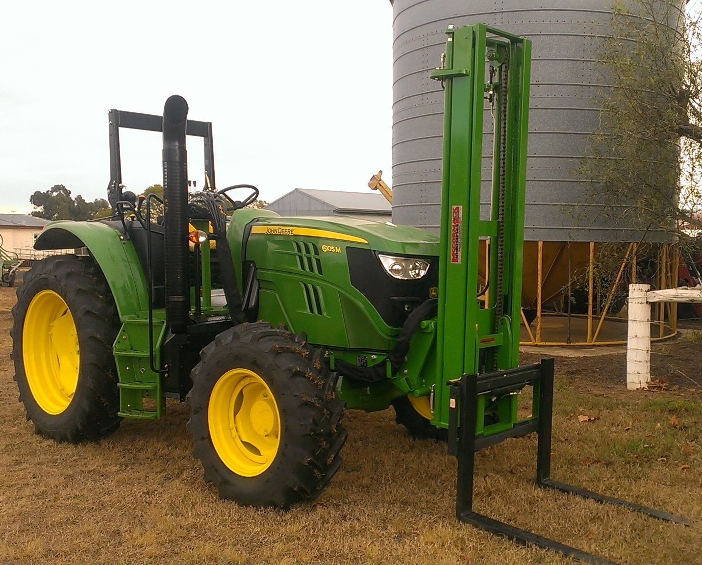 A photo of a McCormack Fork Lift Attachment fitted to a John Deere tractor