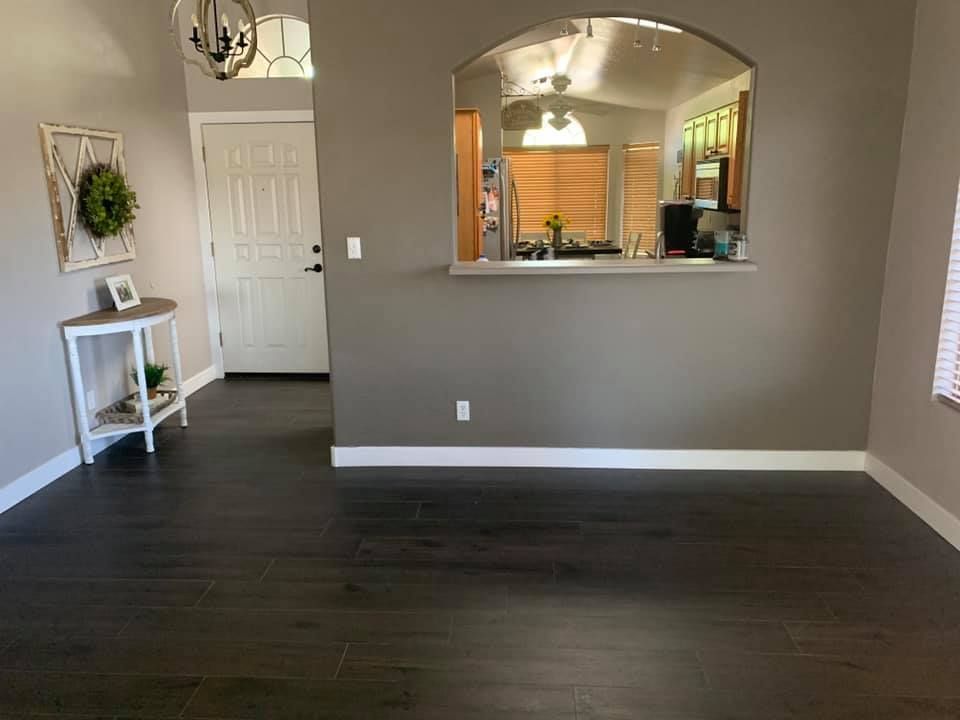 A living room with hardwood floors and a view of the kitchen.