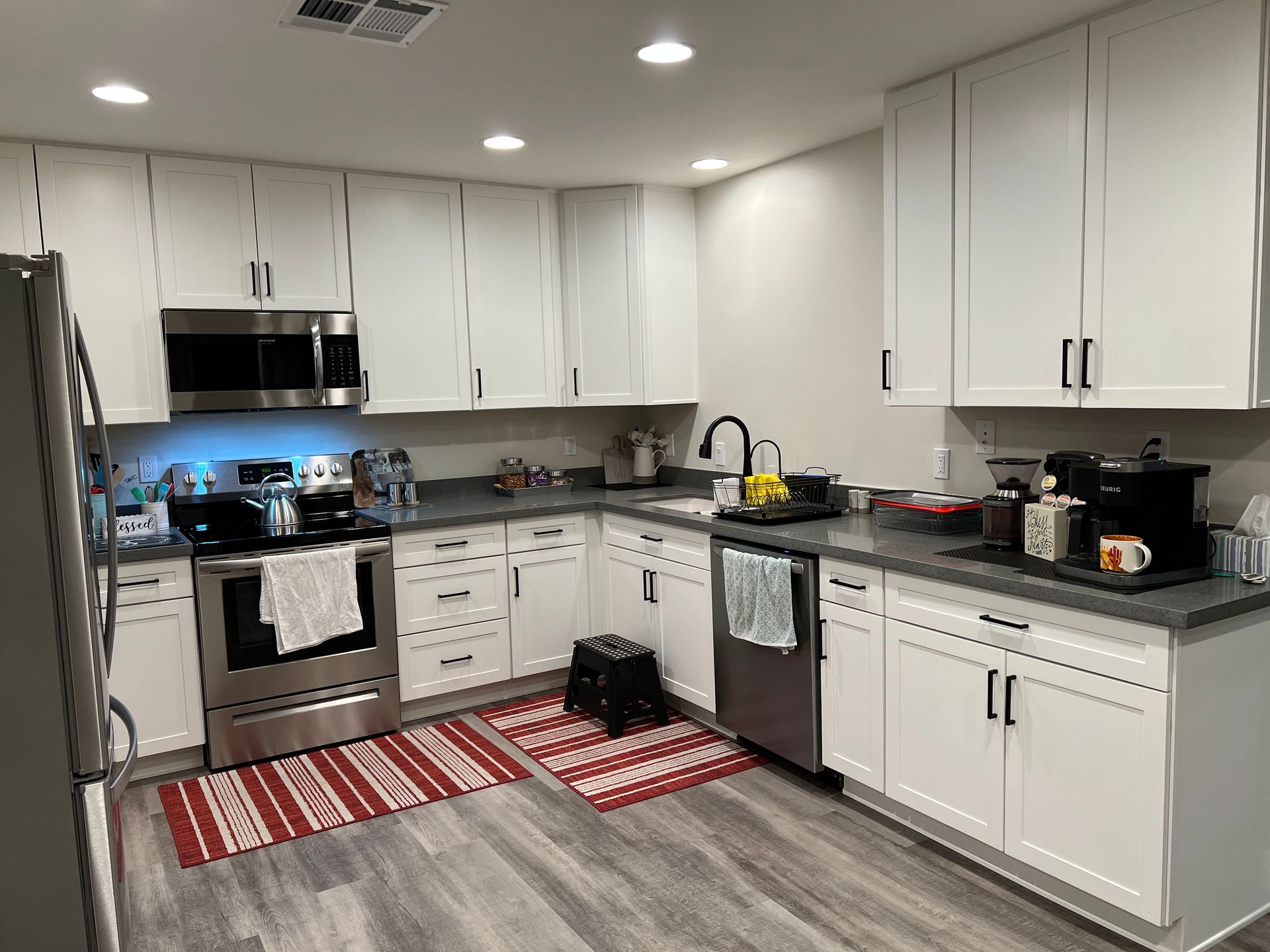 A kitchen with white cabinets and stainless steel appliances