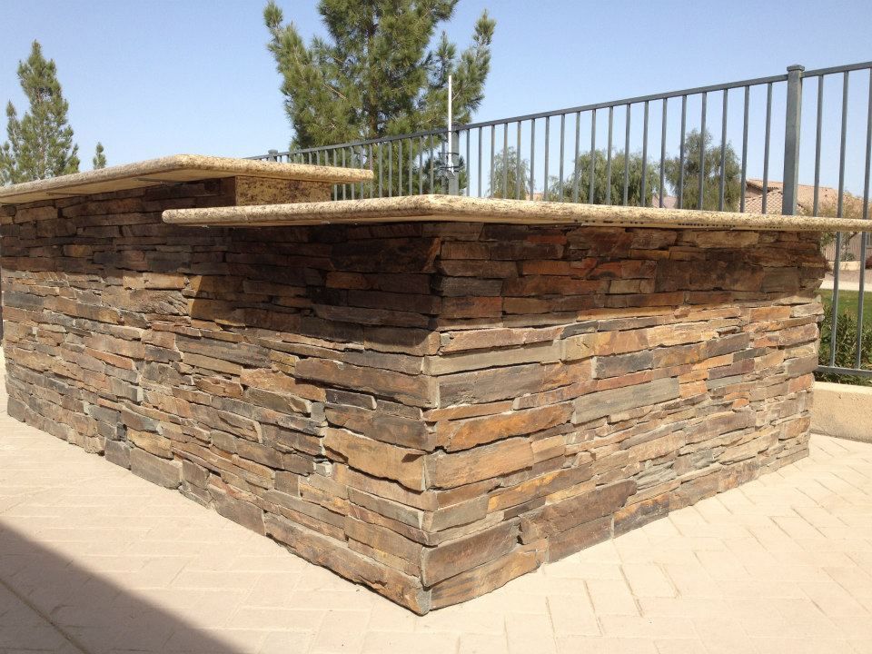 A stone wall with a metal railing behind it