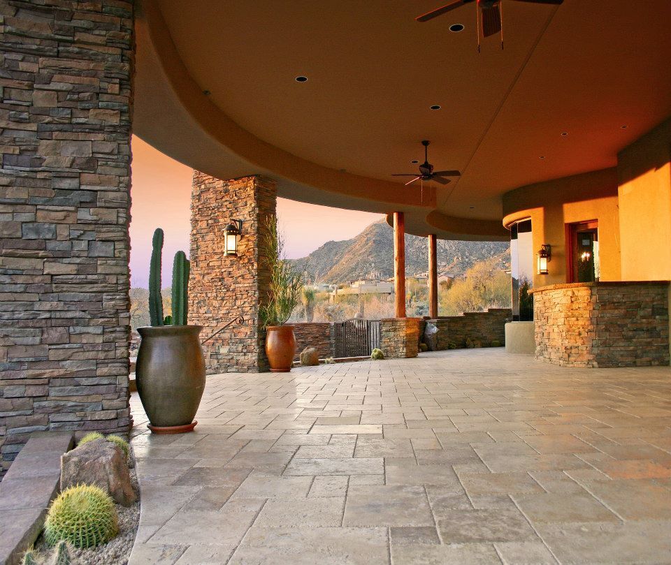 A patio with a ceiling fan and potted plants