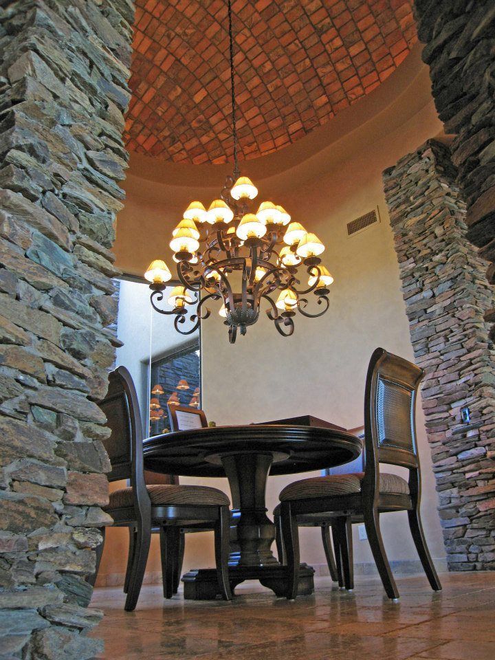 A dining room with a table and chairs and a chandelier hanging from the ceiling